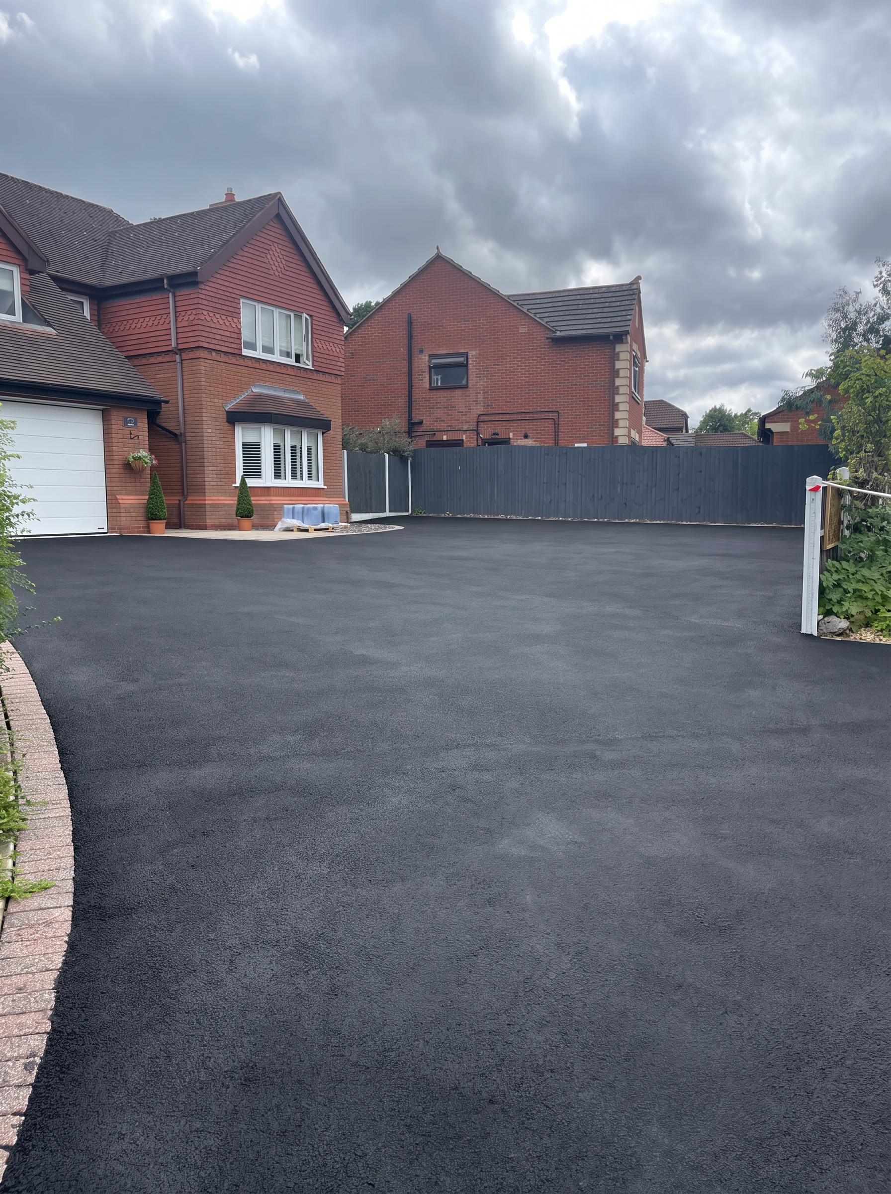A freshly recoloured deep black tarmac driveway at a Staffordshire home